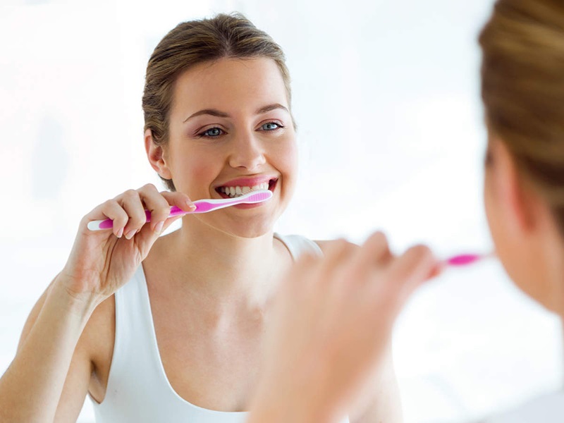Thực hiện vệ sinh răng miệng sạch sẽ bằng việc sử dụng bàn chải lông mềm